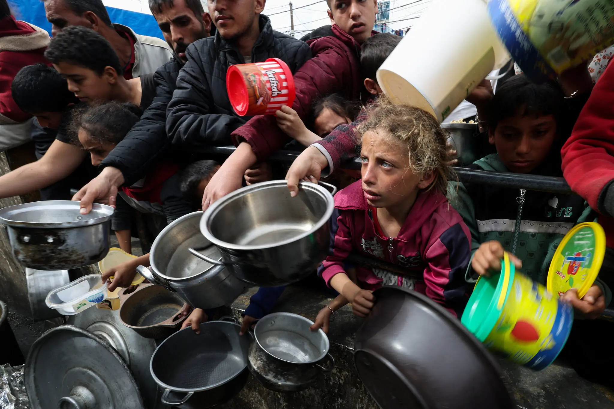 فلسطينيون مع أطفالهم ينتظرون الحصول على المساعدات الغذائية في رفح. تصوير إبراهيم أبو مصطفى رويترز