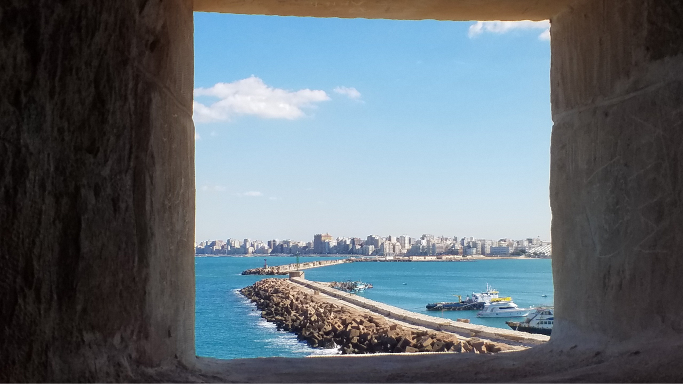 Vue du littoral d’Alexandrie à travers une ouverture dans un mur de pierre