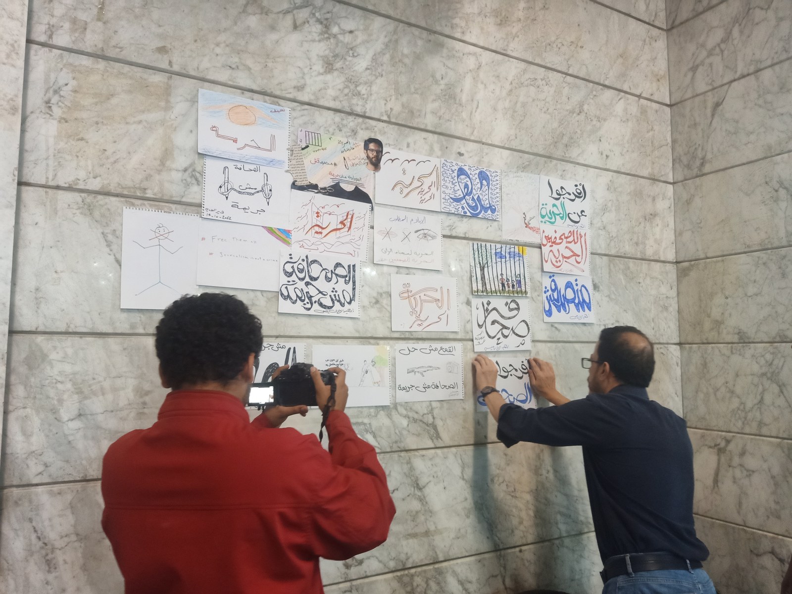 Participants hang solidarity posters on the syndicate’s walls.